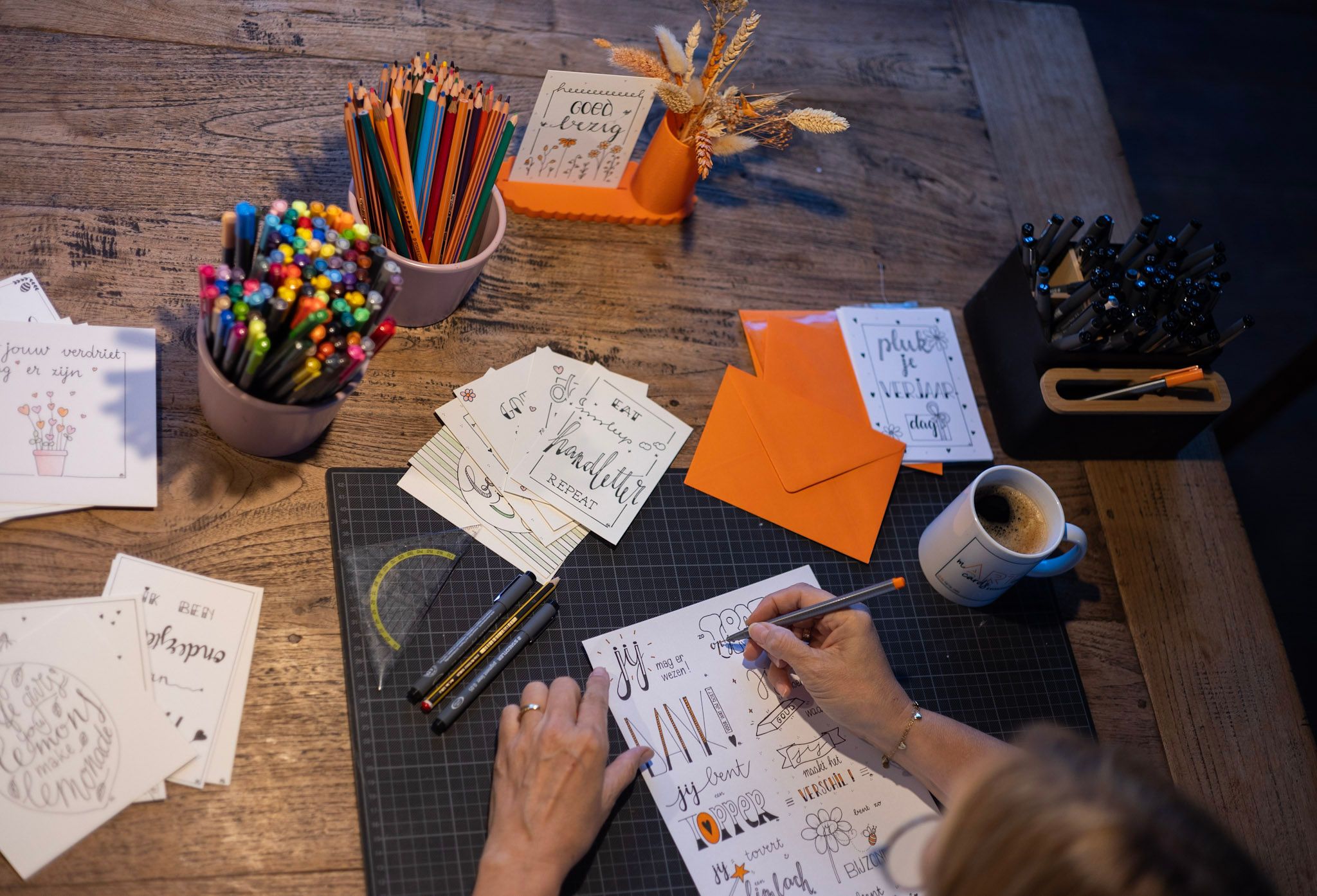 Sfeerbeeld van het atelier, handen die letteren